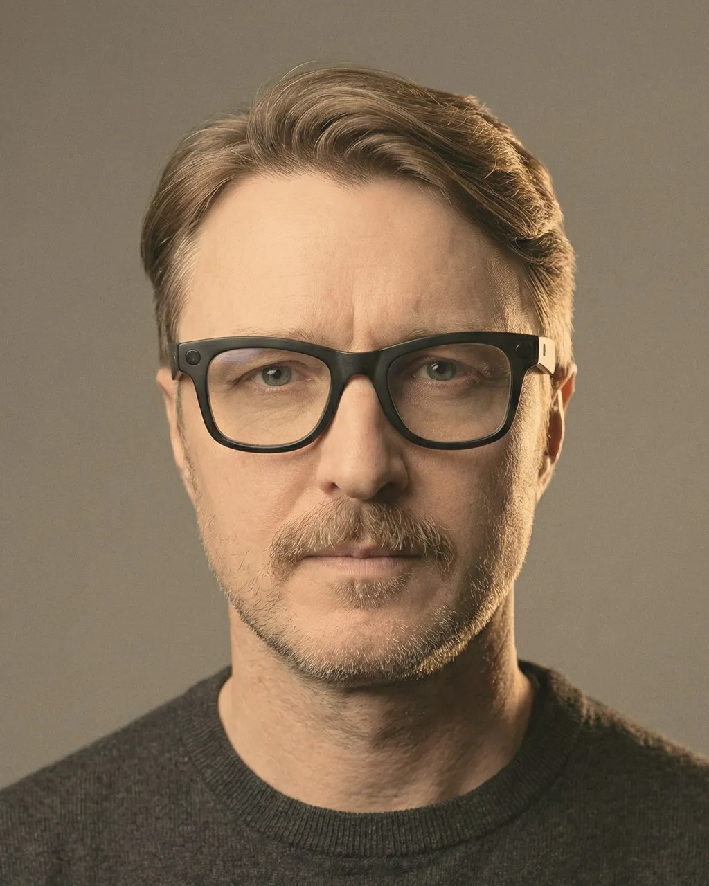 Dmitry Dichkovski in dark-framed glasses and a charcoal sweater, looking directly at the camera.